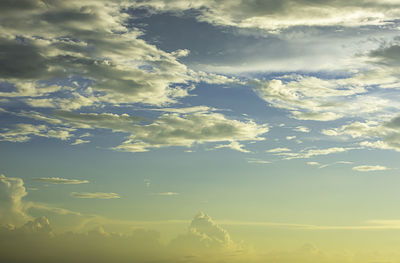 Low angle view of sunlight streaming through clouds