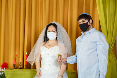 Midsection of couple standing against curtain