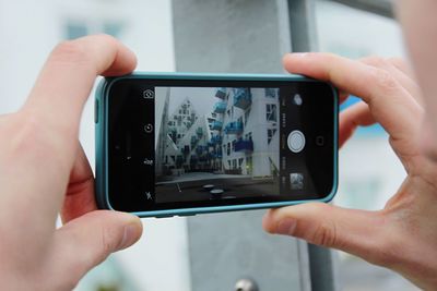 Close-up of cropped hand holding camera