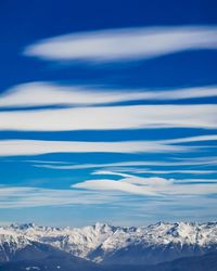 Scenic view of snowcapped mountains against blue sky