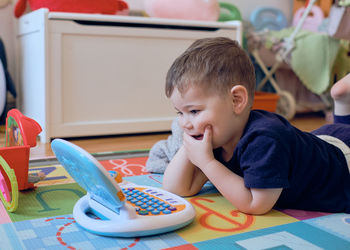 Curious little toddler playing with his toy computer