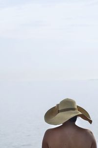 Rear view of woman wearing hat against sea