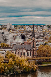 Buildings in city against cloudy sky