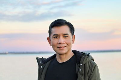 Portrait of young man standing at beach