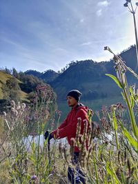 Woman standing by plants against sky