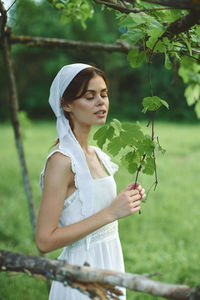 Portrait of young woman holding plant