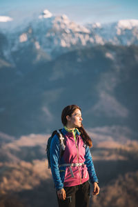 Young man standing against mountain