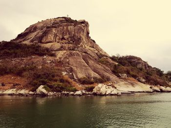 Scenic view of rock formation in sea against sky