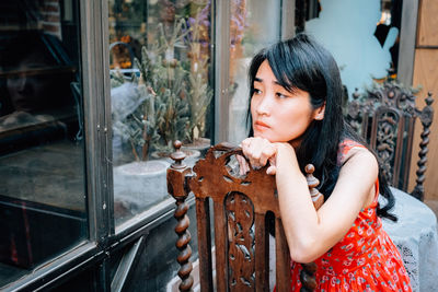 View of depressed woman looking away while sitting on chair