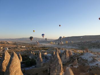 View of hot air balloons flying over landscape