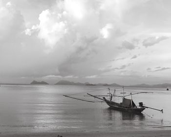 Boat moored in sea against sky