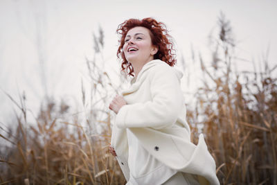 Pretty young woman in trendy white clothes poses in motion