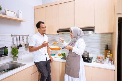 Friends standing on cutting board at home