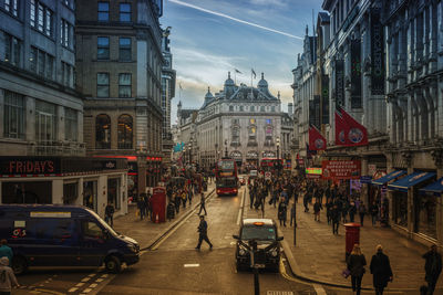 People walking on road in city against sky