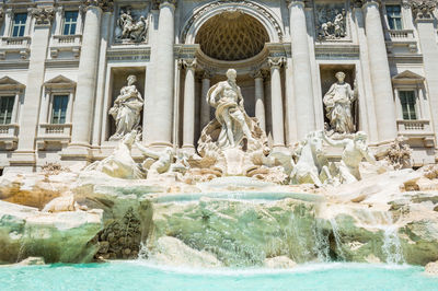 Statue of fountain in front of historical building