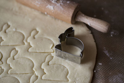 High angle view of cookie cutter on dough in kitchen