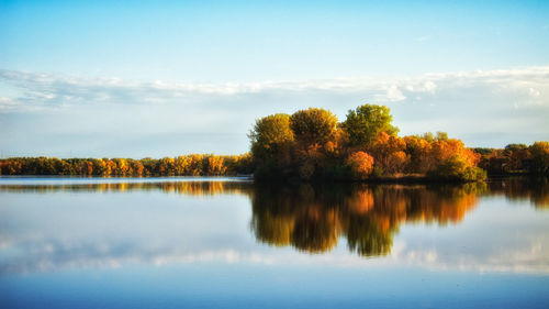 Scenic view of lake by trees against sky