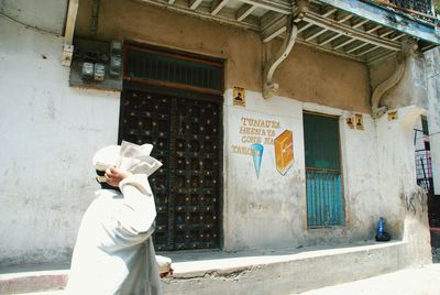 Rear view of man standing in front of building