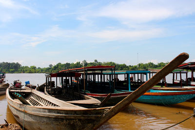 Boats moored in river against sky