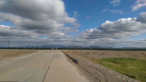 Road by landscape against sky