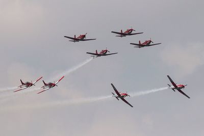 Low angle view of fighter planes flying against sky