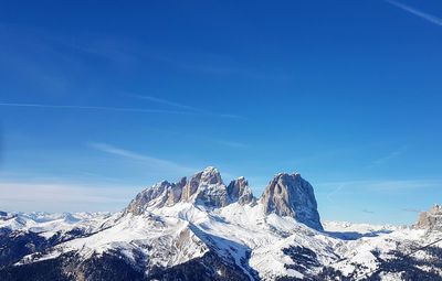 Scenic view of snowcapped mountains against blue sky