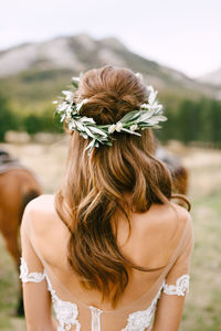 Rear view of woman wearing flowers outdoors