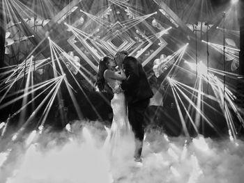 Side view of man and woman standing at music concert