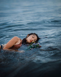 Portrait of woman lying in sea