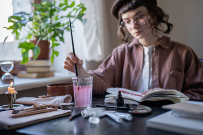 Portrait of young woman working at table