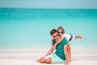 Man wearing sunglasses on beach against sky