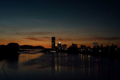 Reflection of buildings in water at sunset