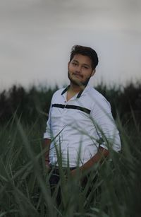 Portrait of young man standing on field