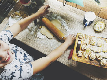 High angle view of girl rolling cookie at home