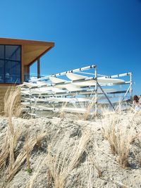 Built structure on field against clear blue sky