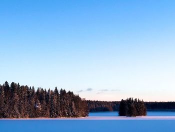 Scenic view of lake against clear sky during winter