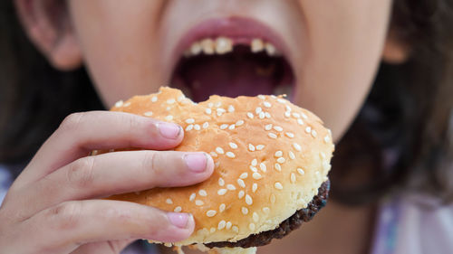Close-up of hand holding hamburger