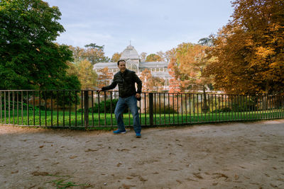 Rear view of man standing by tree against sky