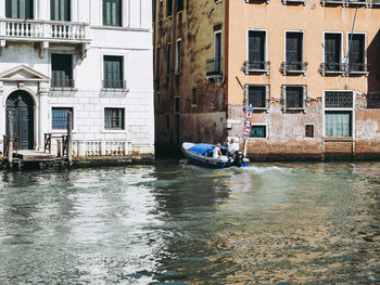 Canal by buildings in city