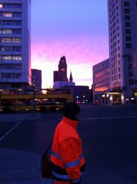 Rear view of man on city street at dusk