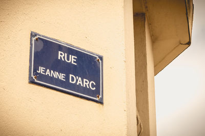 Low angle view of information sign on wall