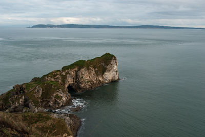 High angle view of calm beach against clouds