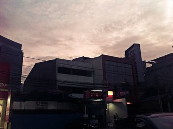 Buildings in city against sky at sunset