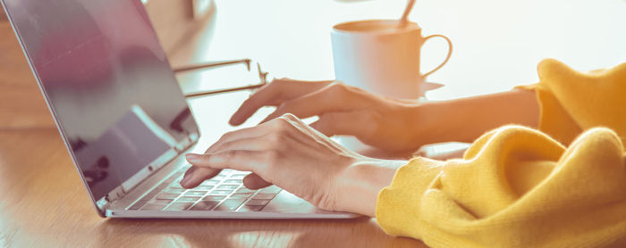 Midsection of man using laptop on table