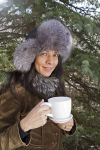 Portrait of smiling woman with coffee cup in winter