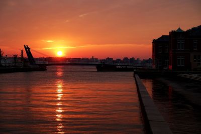 Scenic view of river against orange sky during sunset