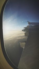 Airplane flying in sky seen through glass window