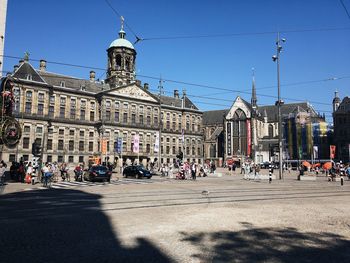 Group of people on street against buildings in city
