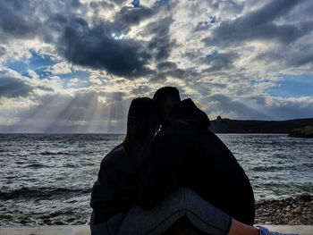 Rear view of couple on sea against sky