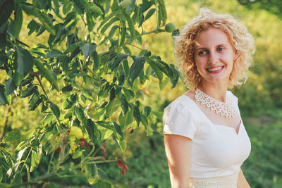 Smiling young woman standing outdoors